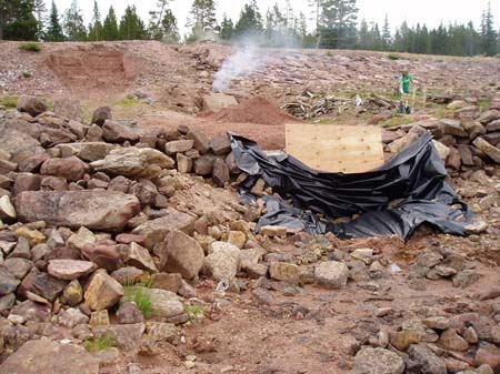 03-Clements Lake Stabilization, heat from burning logs removed from shoreline crack vault, materials are broken up with hand tools